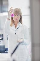 pesquisador feminino segurando um tubo de ensaio em laboratório foto