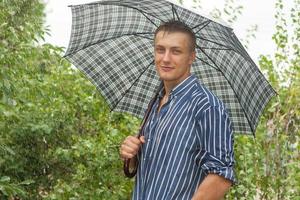 homem com guarda-chuva na chuva foto