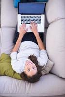 jovem mulher usando laptop em casa vista superior foto