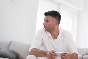 jovem usando um telefone celular em casa foto