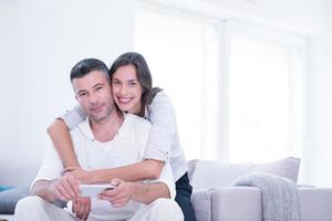 casal feliz usando celular em casa foto