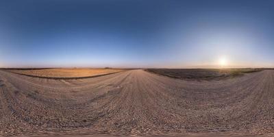 panorama hdr esférico completo sem costura visão de ângulo de 360 graus em estrada de cascalho sem tráfego entre campos na noite de primavera com céu claro em projeção equirretangular, para conteúdo de realidade virtual vr ar foto