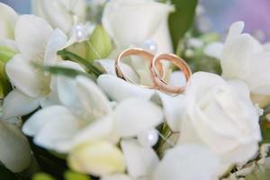 buquê de casamento brilhante de flores de verão com anéis de casamento foto