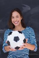 mulher segurando uma bola de futebol na frente da prancheta de giz foto