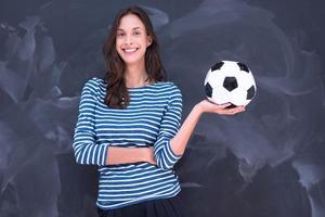 mulher segurando uma bola de futebol na frente da prancheta de giz foto