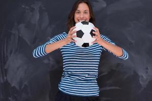 mulher segurando uma bola de futebol na frente da prancheta de giz foto