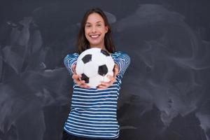 mulher segurando uma bola de futebol na frente da prancheta de giz foto