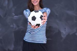 mulher segurando uma bola de futebol na frente da prancheta de giz foto