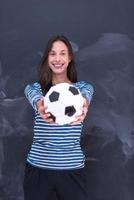 mulher segurando uma bola de futebol na frente da prancheta de giz foto