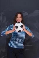 mulher segurando uma bola de futebol na frente da prancheta de giz foto