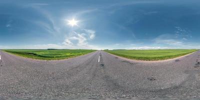 panorama esférico sem costura visão de ângulo de 360 graus em estrada de asfalto velha sem tráfego entre campos com céu claro em projeção equirretangular, conteúdo vr ar foto