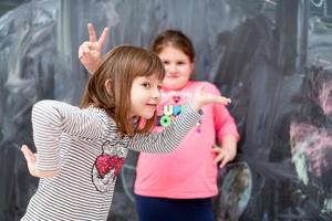 meninas se divertindo na frente do quadro-negro foto