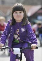 menina bonitinha dirigindo bicyle em dia ensolarado foto