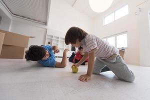 meninos se divertindo com uma maçã no chão foto