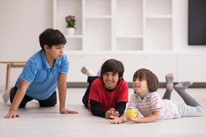 meninos se divertindo com uma maçã no chão foto