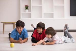 meninos se divertindo com uma maçã no chão foto