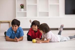 meninos se divertindo com uma maçã no chão foto