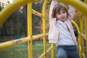 menina bonitinha se divertindo no playground foto