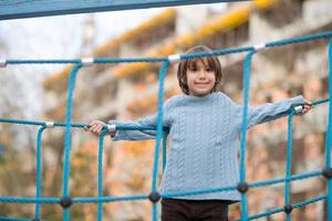 menino bonitinho se divertindo no playground foto