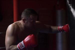 kick boxer treinando em um saco de pancadas foto