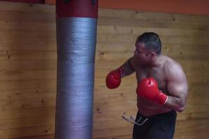 kick boxer treinando em um saco de pancadas foto