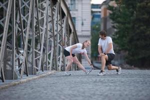 casal aquecendo e alongando antes de correr foto