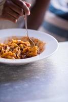 uma jovem afro-americana comendo macarrão foto