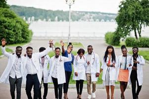 grupo de estudantes de medicina africanos posou ao ar livre em jalecos brancos. foto