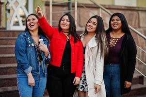 grupo de quatro meninas latinas felizes e bonitas do Equador posou na rua. foto