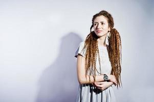 sessão de estúdio de garota de vestido cinza com dreads em fundo branco. foto