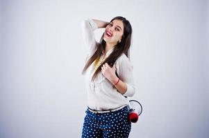 retrato de uma jovem de calça azul e blusa branca posando com megafone no estúdio. foto