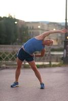 homem bonito se alongando antes de correr foto