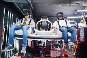 dois jovens indianos se divertindo com uma nova tecnologia de um fone de ouvido vr no simulador de realidade virtual. foto