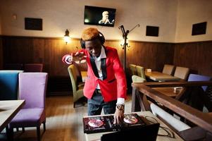 moda homem afro-americano modelo dj no terno vermelho com controlador de dj. foto