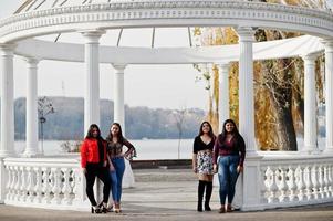 grupo de quatro meninas latinas felizes e bonitas do Equador posou na rua contra o antigo arco. foto