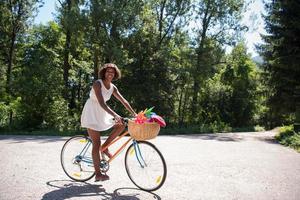 muito jovem afro-americana andando de bicicleta na floresta foto