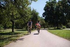 jovem casal multiétnico dando um passeio de bicicleta na natureza foto