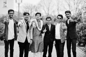 grupo de seis homens indianos do sul da Ásia em roupas tradicionais, casuais e de negócios em pé e mostra o polegar para cima. foto