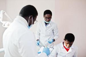 três médicos afro-americanos trabalhando, discutindo com colegas na clínica. foto