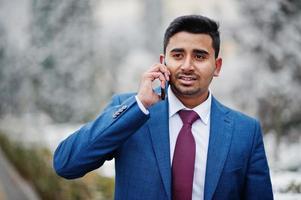 elegante modelo de homem elegante indiano de terno posou em dia de inverno e falando no telefone. foto
