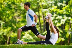 casal fazendo exercícios de alongamento depois de correr foto