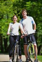 casal feliz andando de bicicleta ao ar livre foto