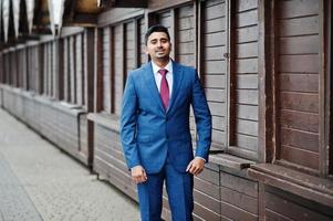 elegante modelo de homem elegante indiano de terno posou contra barracas de madeira. foto