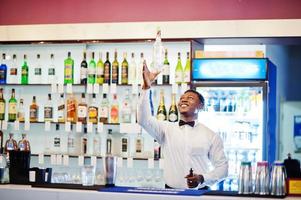 barman americano africano no bar flair em ação, trabalhando atrás do bar de coquetéis. preparação de bebidas alcoólicas. foto