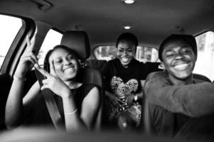 jovens amigos afro-americanos sentados dentro de um carro. foto
