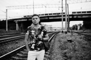 retrato de estilo de vida de homem bonito posando na estação de trem. foto