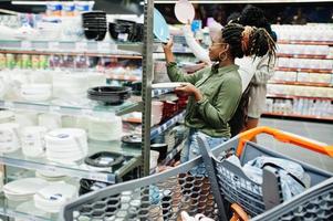 grupo de mulheres africanas procuram placas coloridas nas prateleiras dos supermercados. foto