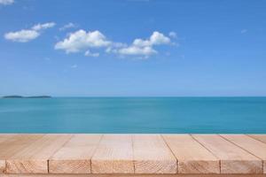 tampo da mesa de madeira no mar azul turva com fundo de nuvem foto