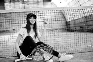 jovem jogador desportivo com raquete de tênis na quadra de tênis. foto
