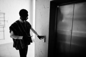 homem afro-americano no elavator ou elevador moderno, apertando o botão. foto